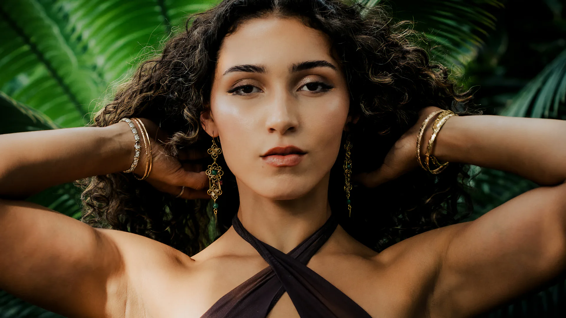 Woman wearing gold earrings and a gold collar